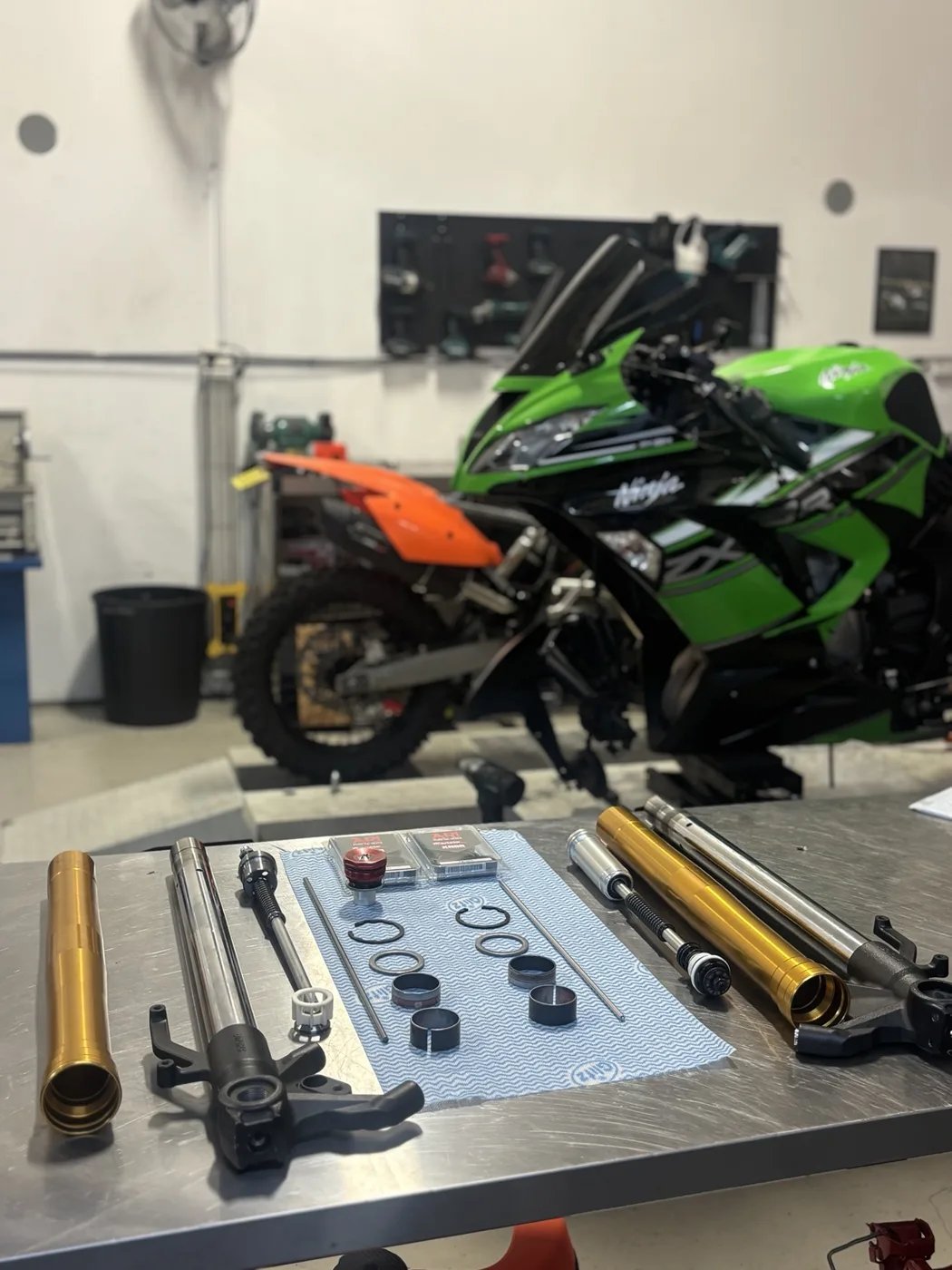 Disassembled fork components arranged on a workshop bench